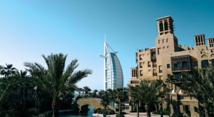 Beautiful daytime view of Burj Al Arab with palm trees and Jumeirah architecture.