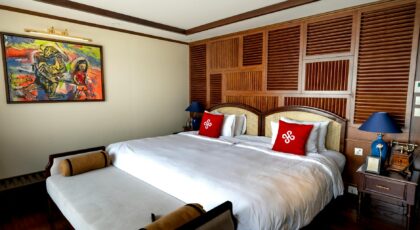 Spacious hotel room featuring a king-sized bed, elegant decor, and colorful artwork.