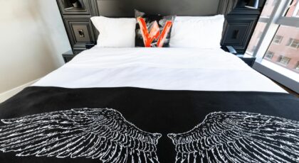 Explore a modern bedroom in Boston with stylish decor and unique wing design bedspread.