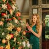 A woman adorns a festive Christmas tree with ornaments in a luxurious interior, exuding holiday warmth.