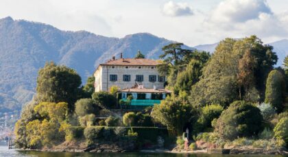 Picturesque villa on the shores of Lake Como surrounded by lush greenery and mountain views.