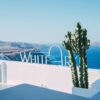 Stunning rooftop view in Santorini featuring a cactus and the serene blue sea. Perfect travel destination.