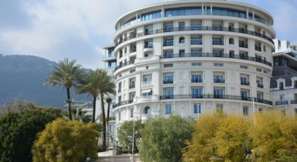 Luxurious round hotel with palm trees, offering an elegant getaway.