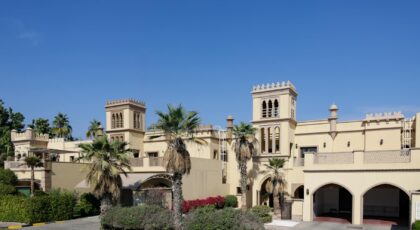 Luxurious Middle Eastern villa with traditional architectural style under a clear blue sky.