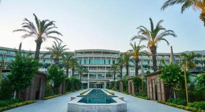 Explore a stunning modern resort featuring a sleek swimming pool surrounded by palm trees.