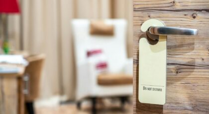 A hotel room door with a 'Do Not Disturb' sign, evoking a sense of privacy and relaxation.