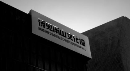 A black and white photo capturing Nanshan's Overseas Chinese Exhibition Hall at dusk.