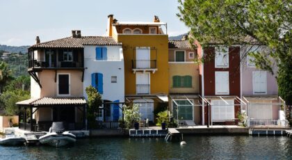 Charming colorful houses by a canal in Provence, showcasing vibrant Mediterranean architecture.