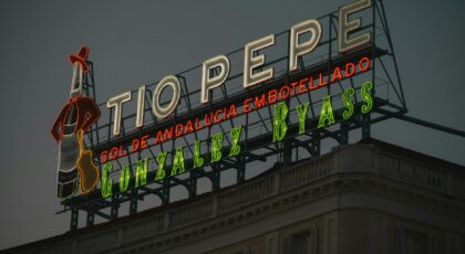 Neon Tío Pepe sign glowing in Madrid during twilight, representing Spanish culture.